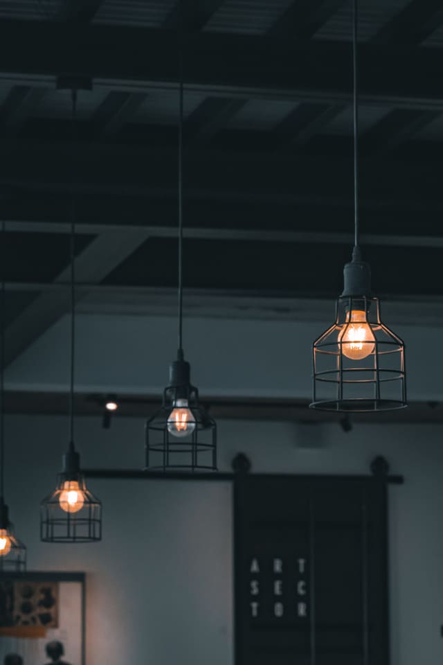 Black industrial pendant lights with warm globes